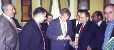 Abduraham Alamoudi (far left), Bush (center), and Rove (far right). Judging from the background, this picture was probably taken in 2000.